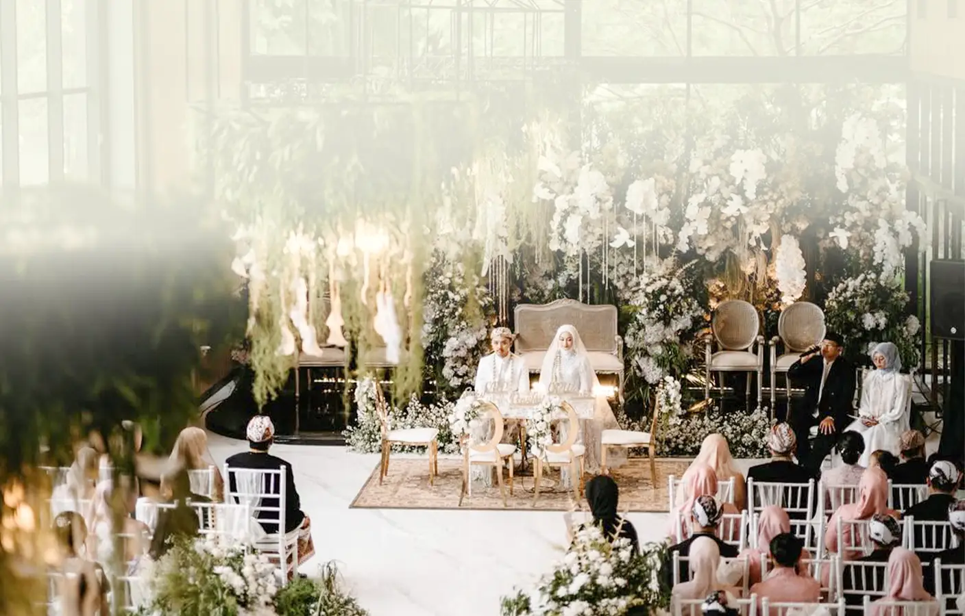 An elegant wedding ceremony with a floral backdrop.
